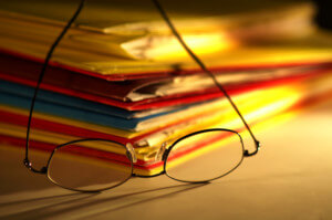 Reading glasses on pile of files