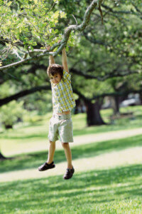 Boy Swinging from Tree --- Image by © Royalty-Free/Corbis